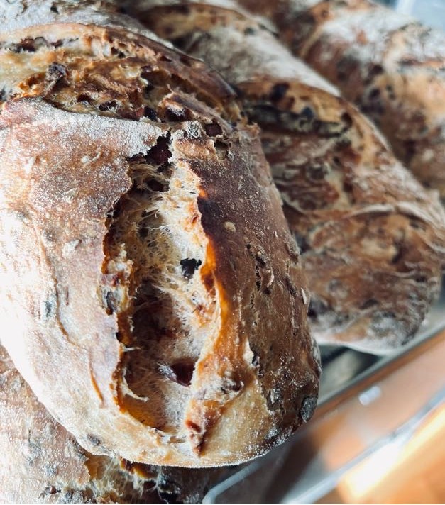 Olivenbaguette Mehrere Brote mit knuspriger Kruste und sichtbarem, weichem Inneren.